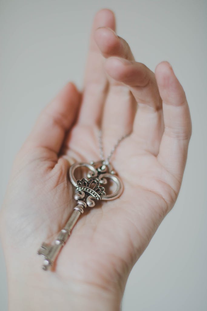 An antique skeleton key rests delicately on a person's open palm, showcasing elegant design.